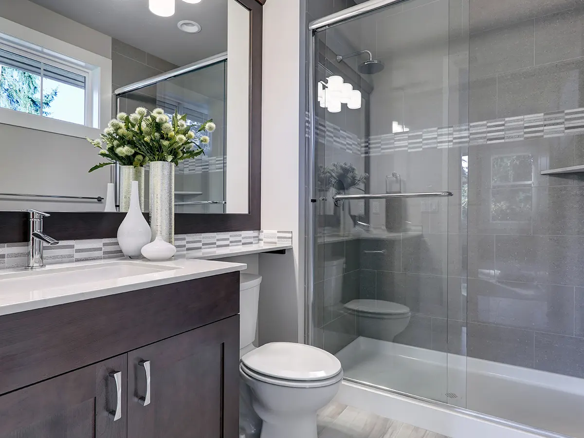 A bath renovation in Mississauga with a glass shower and brown vanity