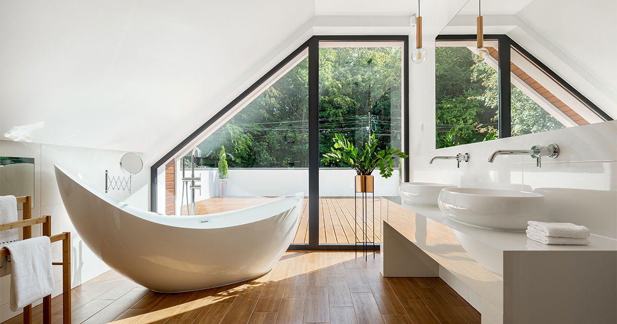 A second floor bathroom with wood floor and a free standing tub with a beautiful view