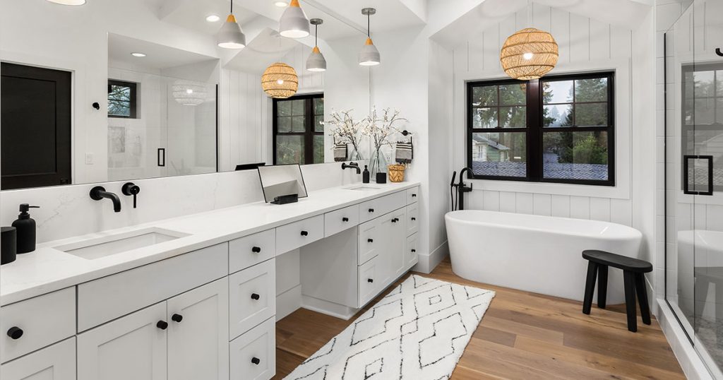 A white bathroom with black hardware and fixtures with yellow lights