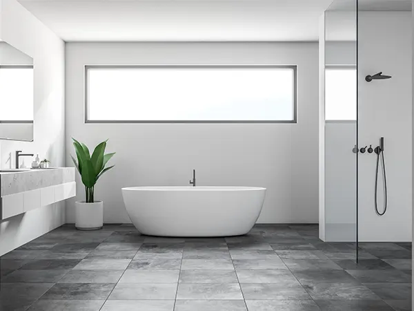A bathroom with dark ceramic floor, white walls, and a plant
