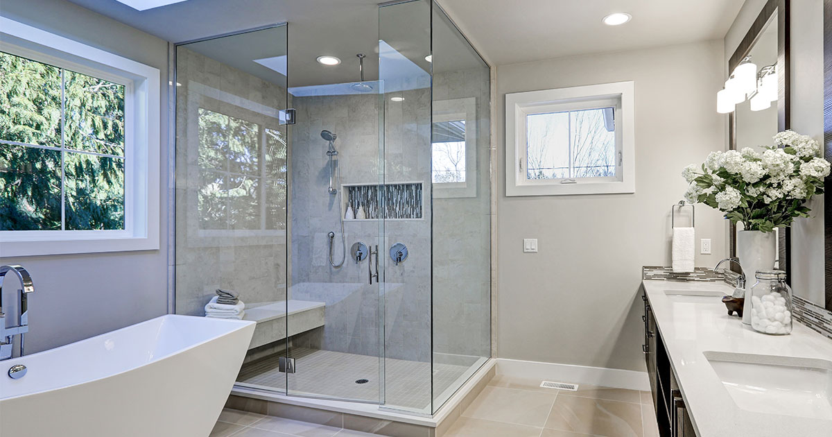 A glass walk-in shower in a spacious bathroom with white flowers