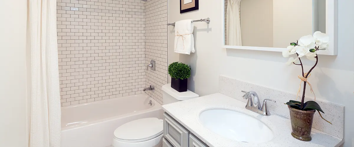 A white bathroom with plants and a tub with a shower curtain