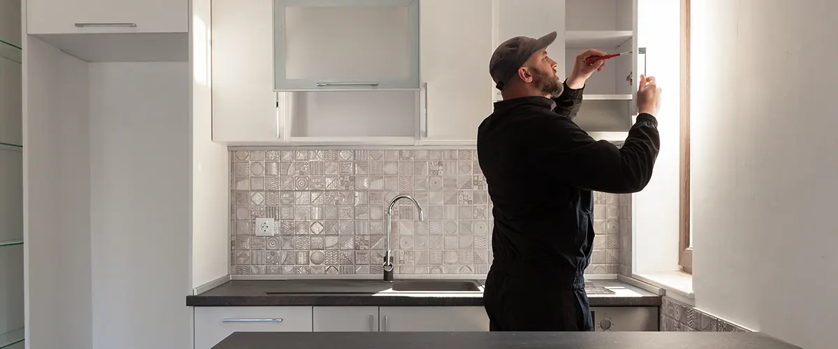 man installing kitchen cabinets