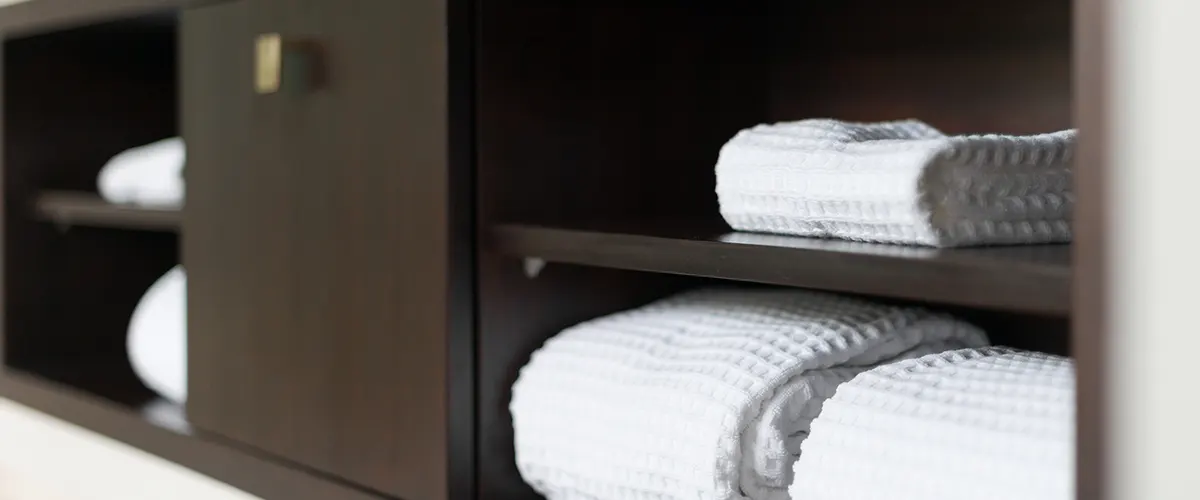 white towels in a wood cabinet