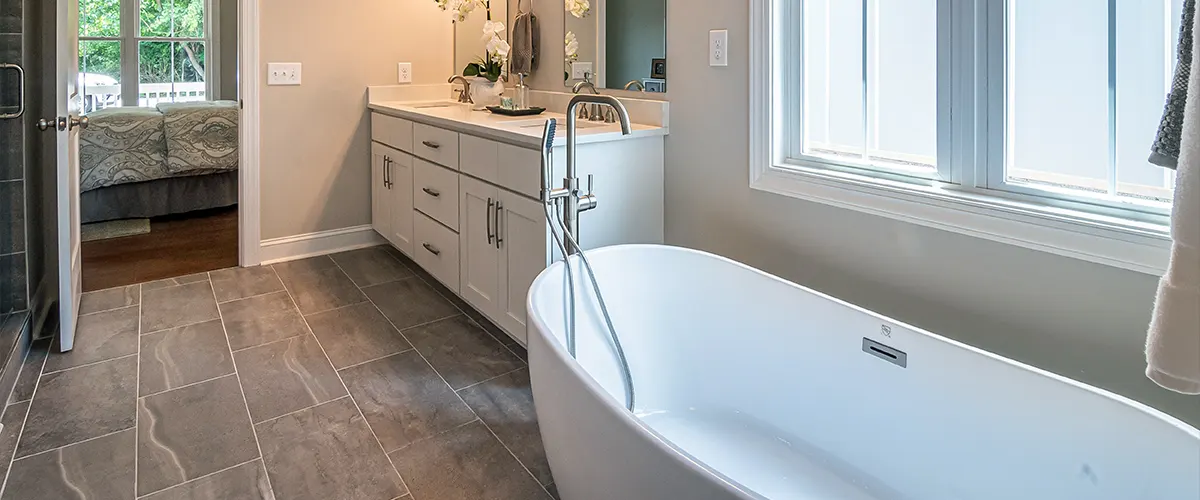 A freestanding tub in a bathroom with an open door