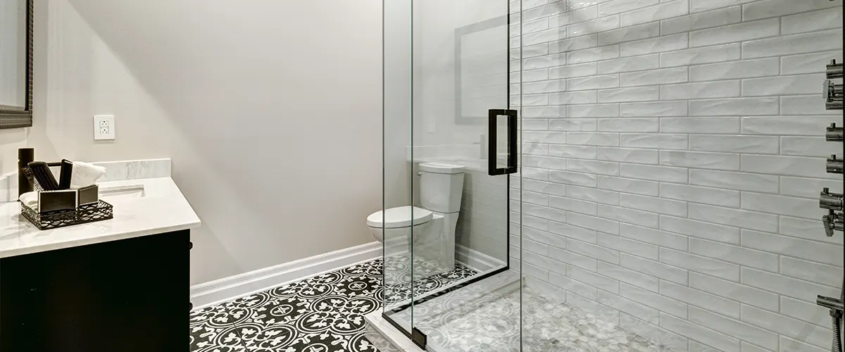 A glass walk-in shower with a toilet behind it