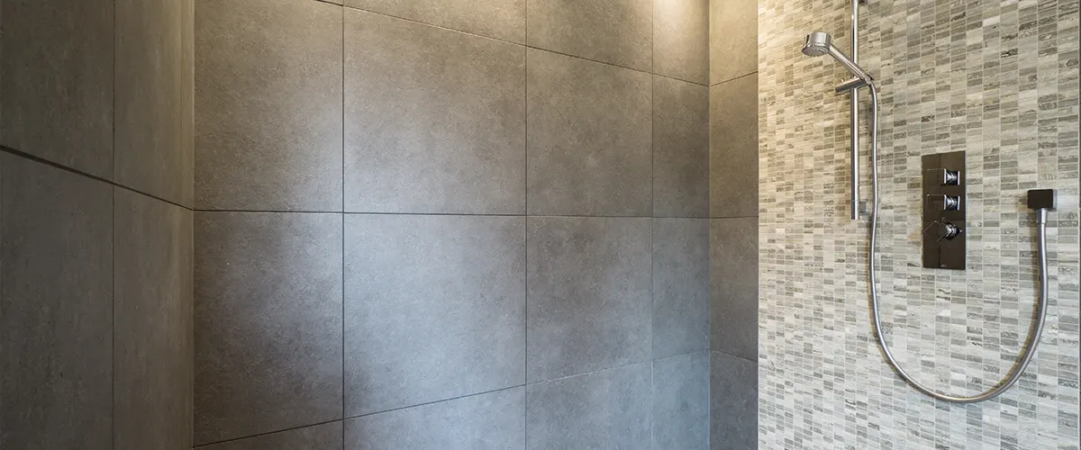 walk-in shower with gray tile pattern