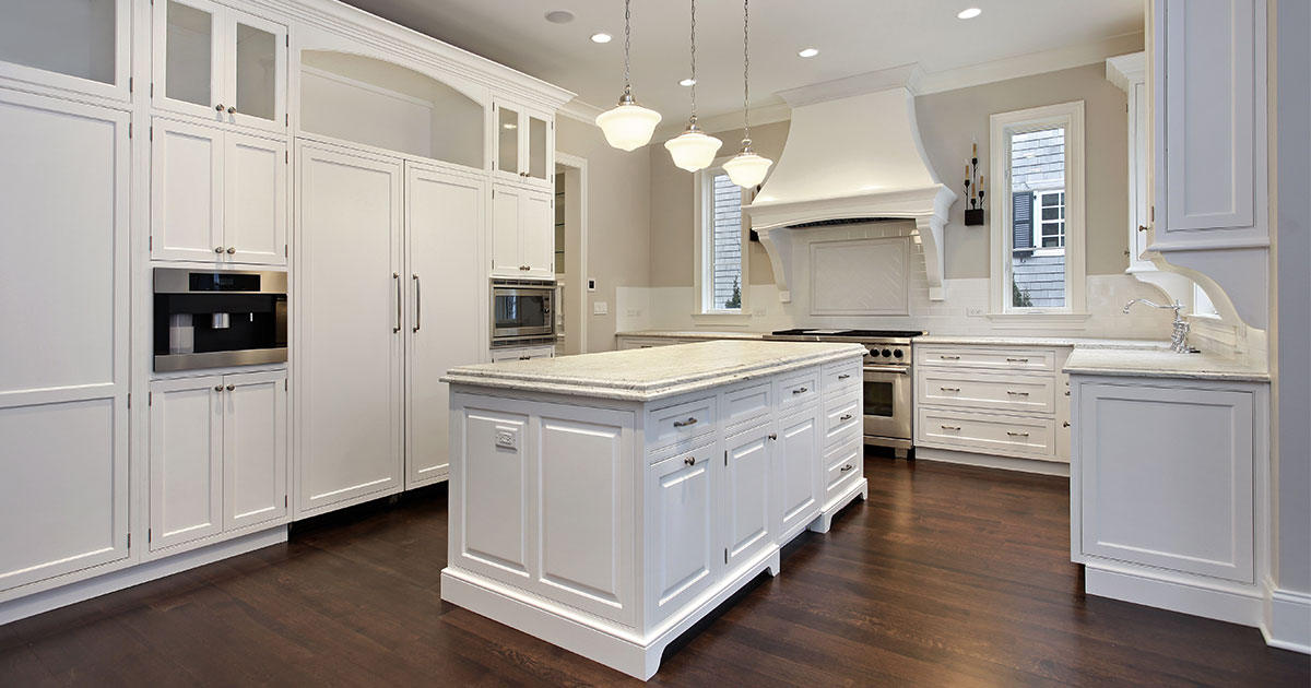 A white kitchen with hardwood floors