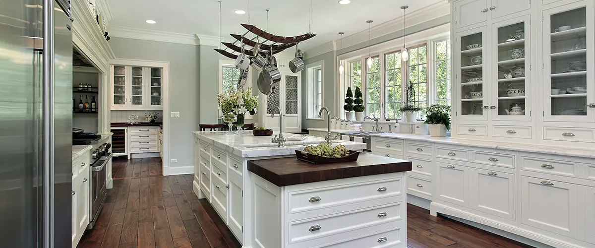 A large kitchen with a small butcher block counter and quartz countertops