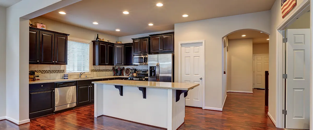 A wooden kitchen floor with hardwood cabinets and lights in the ceiling