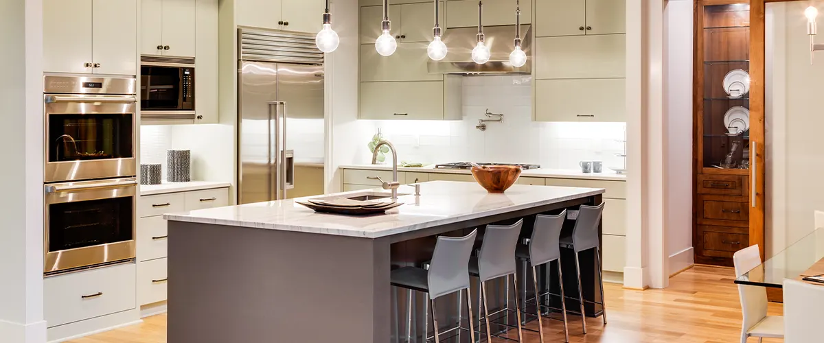 A kitchen renovation in Vaughan with an island and overhead lights with beige cabinets