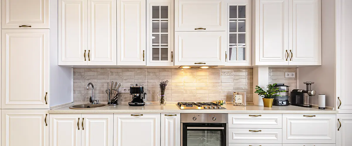 White transitional kitchen cabinets with golden hardware