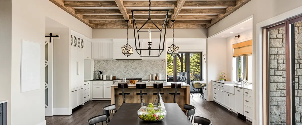 A farmhouse kitchen with a visible wood frame on the ceiling