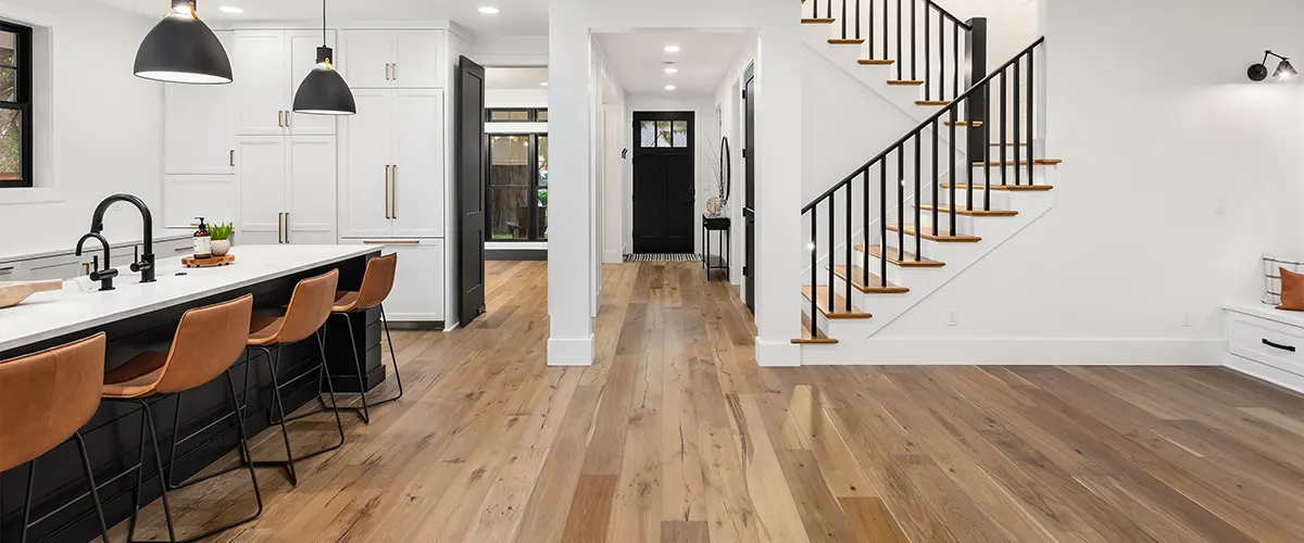 Floating floor in an open-concept kitchen with stairs and black railing