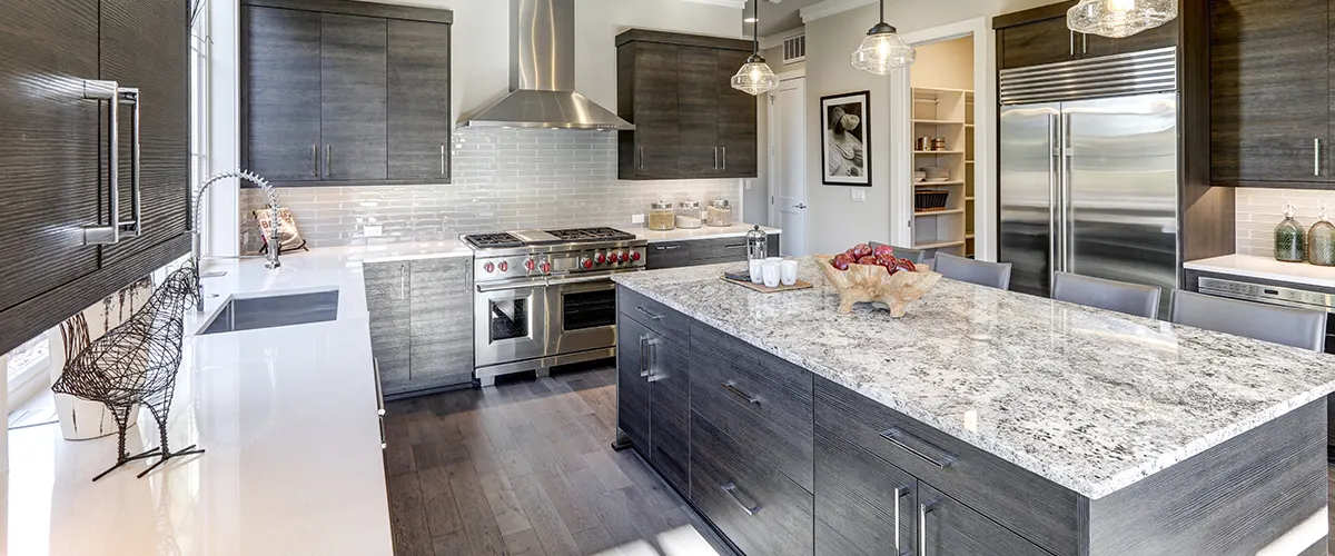 A kitchen with gray cabinets and a quartz countertop