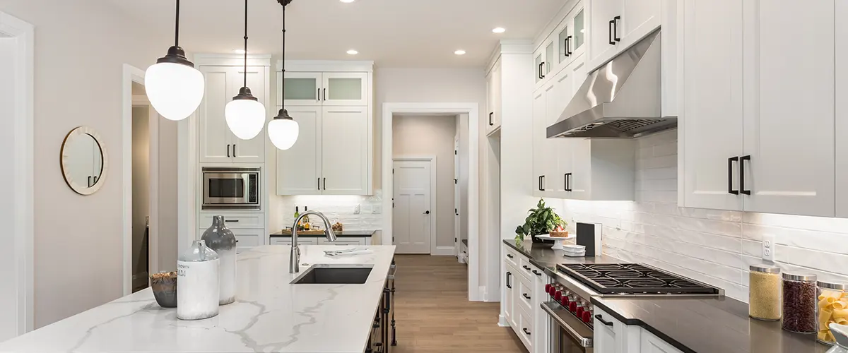 A white kitchen with LVP flooring and transitional cabinets