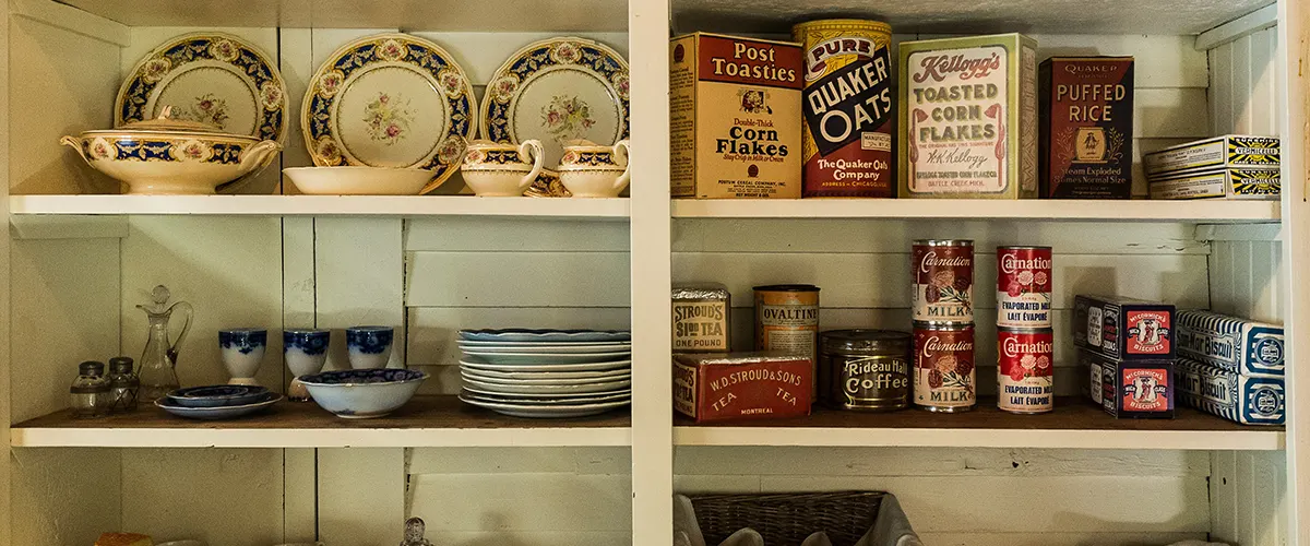 A walk-in pantry filled with plates and canned food
