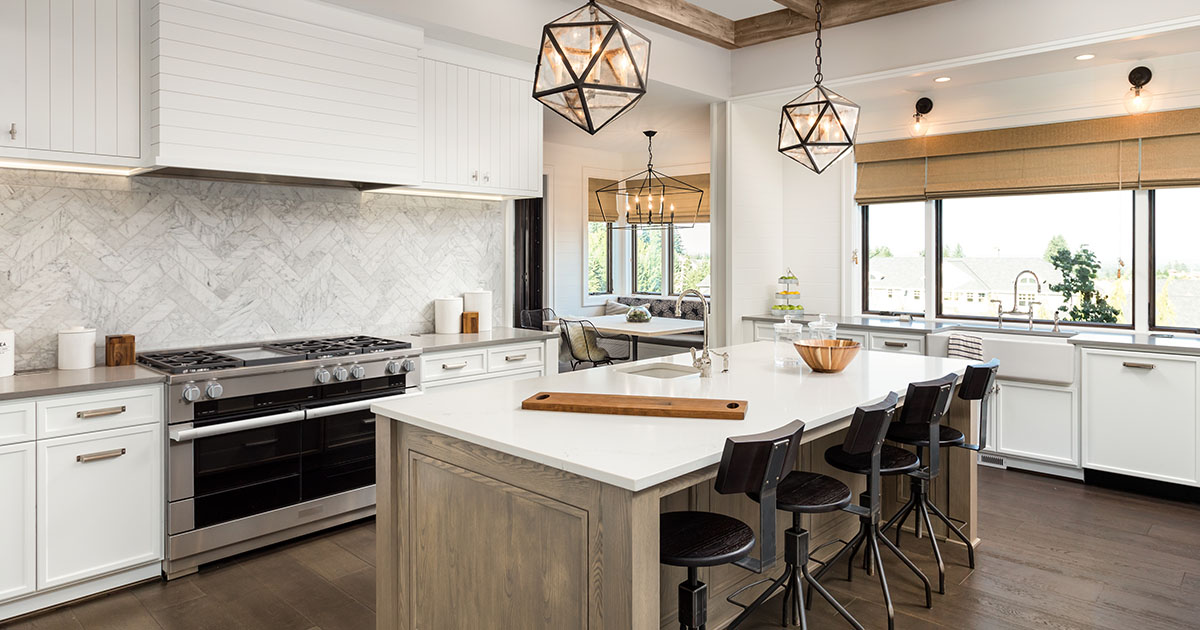 A kitchen with a quartz counter, wood flooring, and white cabinets