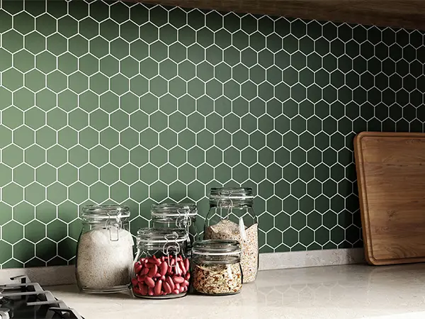 A green decorative backsplash with jars filled with spices