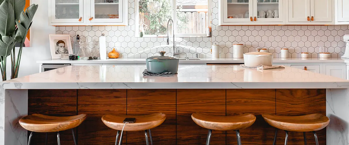 A quartz kitchen island with wood stools