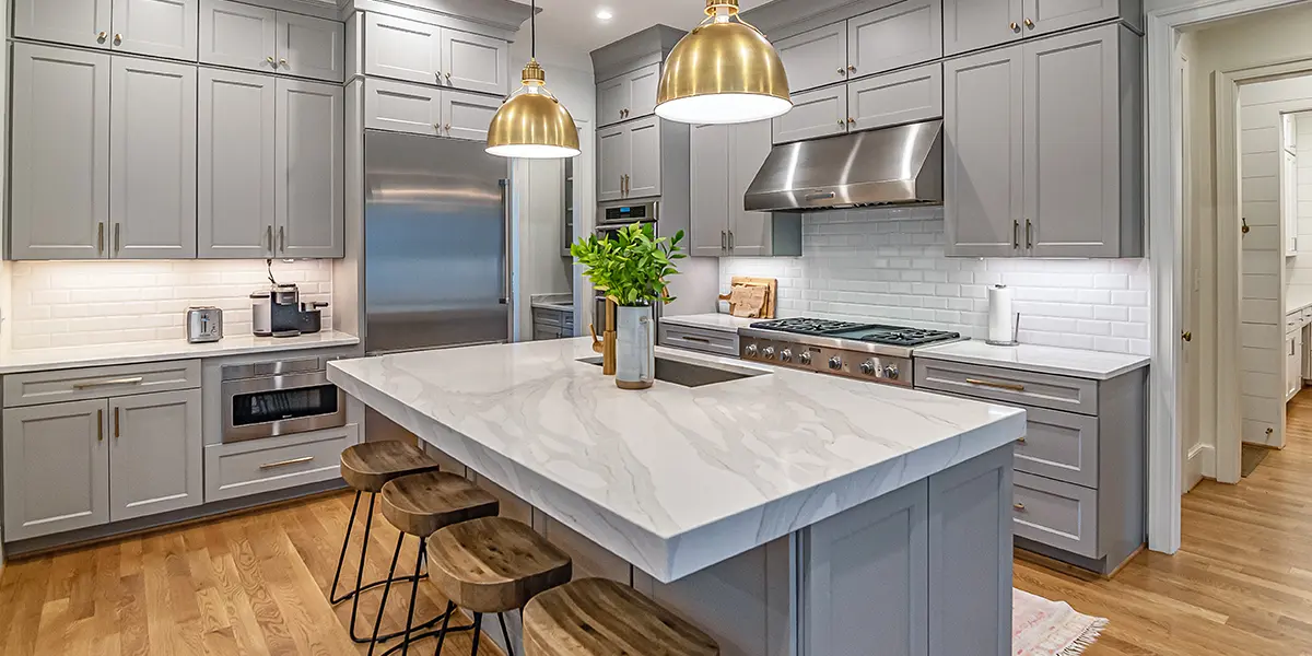 Transitional style kitchen with white cabinets, black ornaments, and black countertop with black custom range hood