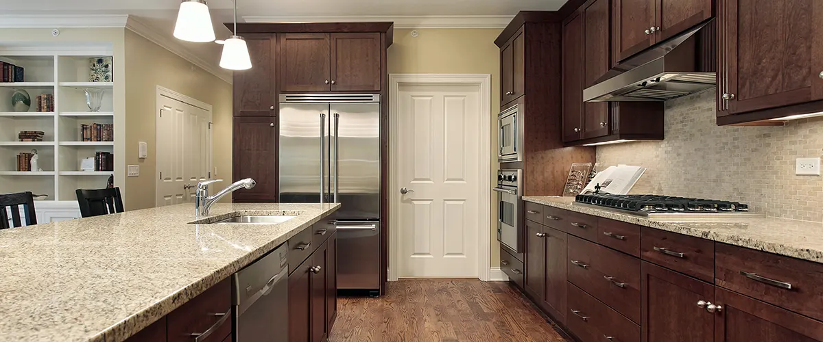 Traditional hardwood kitchen cabinets with light gray quartz countertops