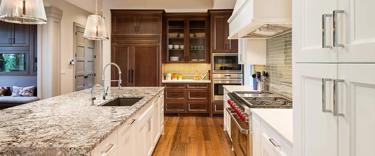 Wood flooring in a kitchen with hardwood cabinets and a granite kitchen island