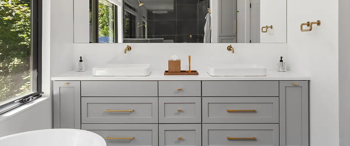 A gray double vanity with golden hardware