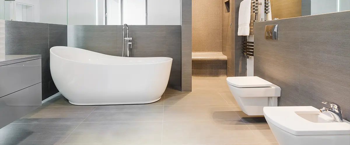 Types of bathroom styles with a large tub and gray tiles on walls