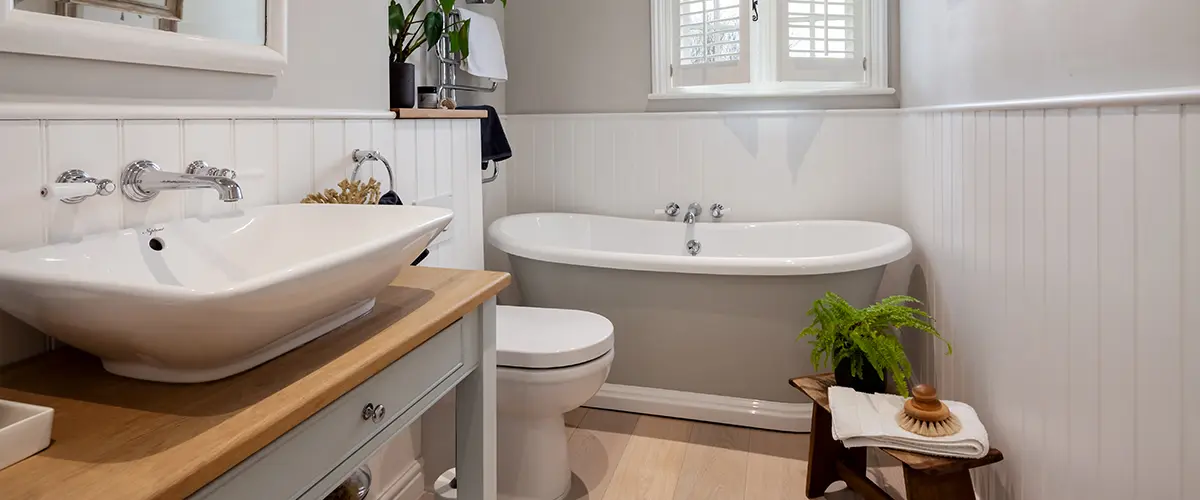 A traditional bath with plants and wood counter